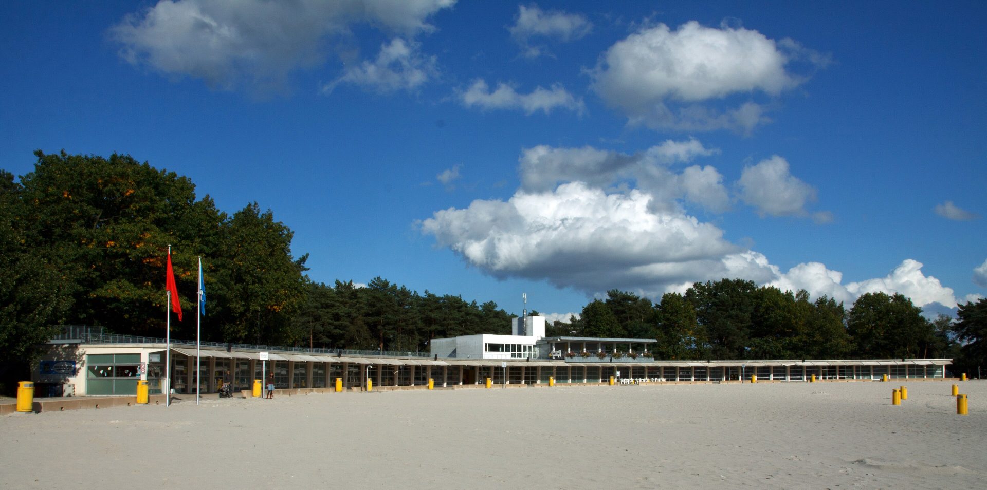 La plage de sable blanc et le bâtiment de plage du domaine provincial du Zilvermeer à Mol, sous un ciel bleu nuageux