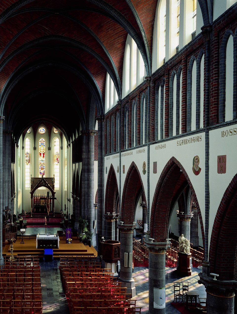 La nef de l’église Saint-Martin à Avelgem, avec ses voûtes en brique et les vitraux derrière le chœur
