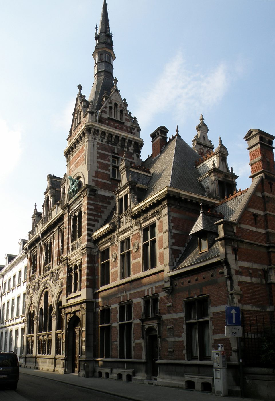 L’ancien bâtiment du conseil provincial dans la Lombaardstraat à Hasselt, en brique rouge et pierre, avec une haute tour coiffée d’une flèche en ardoise